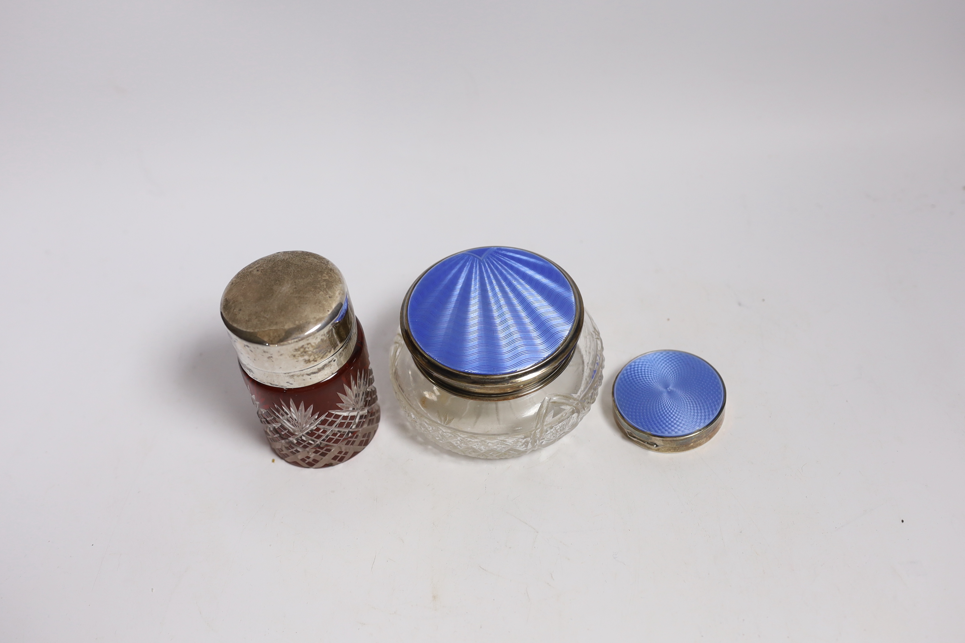A silver and enamel compact, a silver and enamel mounted glass jar and an Edwardian silver mounted cut glass salts jar by William Hutton & Sons, Birmingham, 1904, 85mm.